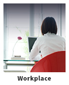 Woman at a laptop looking out a large window with text Workplace