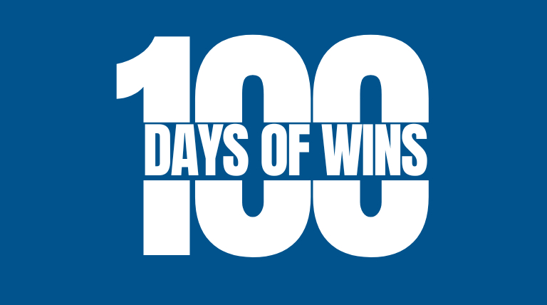 Bold white text on a blue background reads "100 DAYS OF WINS," with "DAYS OF WINS" centered within the number "100."