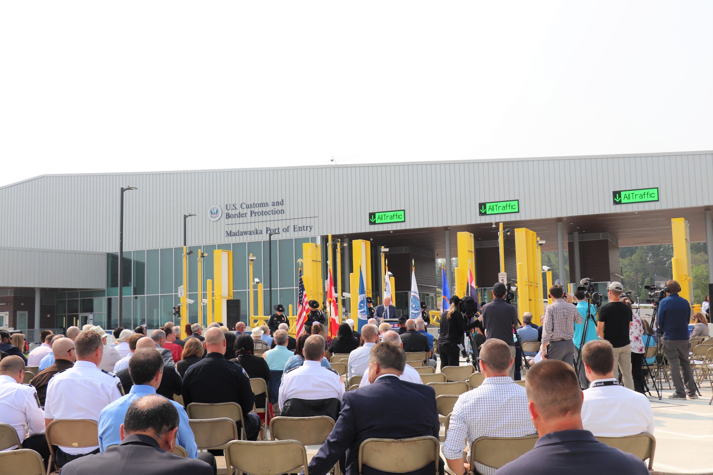 the back of people's heads in the crowd at the ribbon cutting