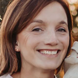 Headshot of Katherine Knecht. Katherine has dark hair and a white sweater.