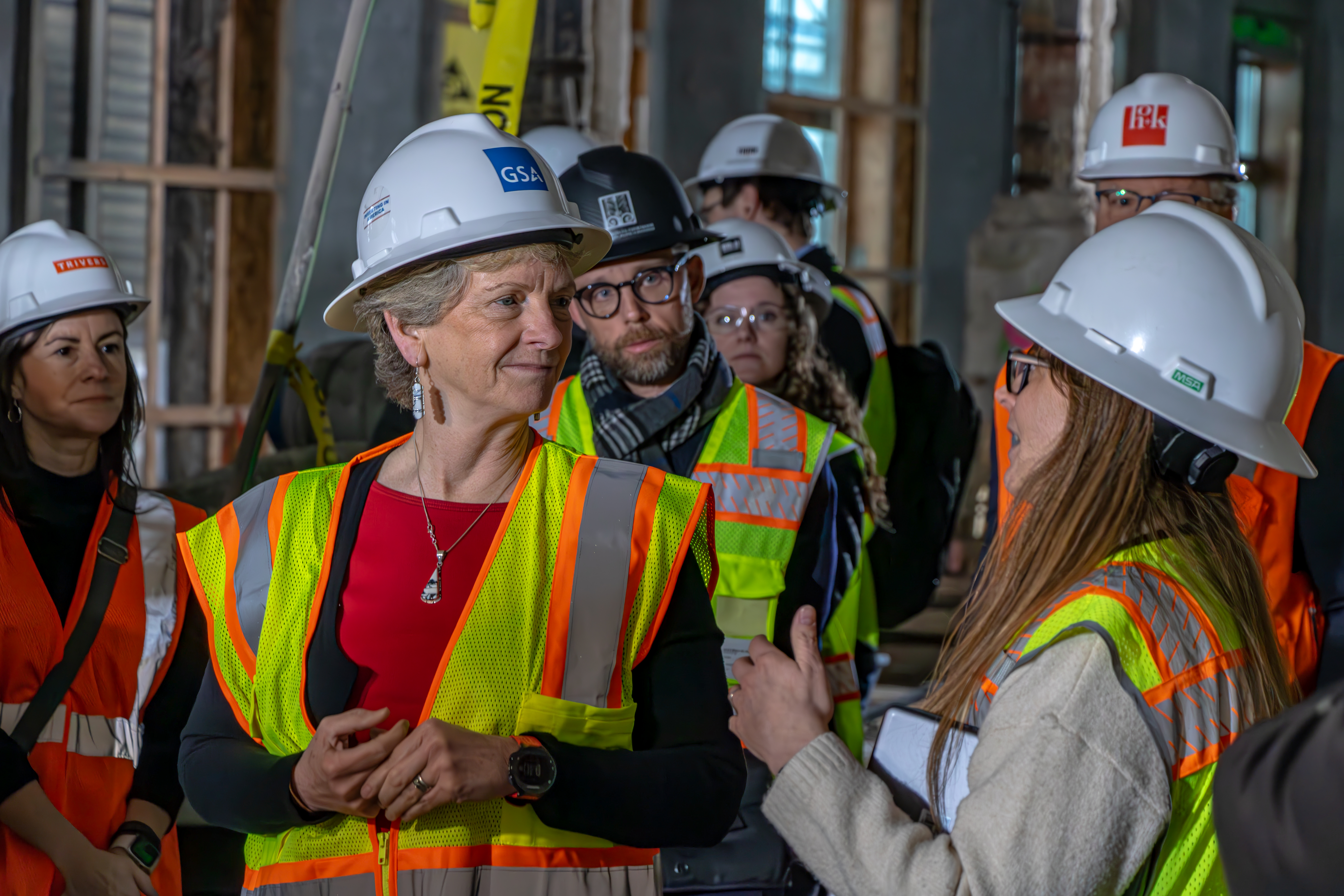 Robin Carnahan, GSA administrator speaks with workers in a building under construction