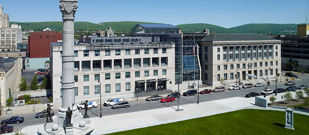 White stone, multi-story building with a glass and steel section in the center