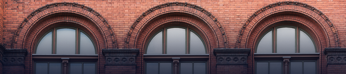 Red brick walls framed with rounded arch windows