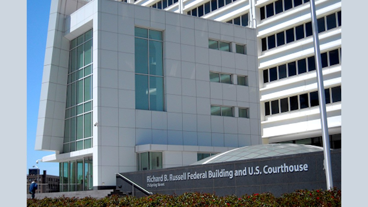 Multi-level white tile and glass building with angled entrance area, and sign saying Richard B Russell Federal Building and U.S. Courthouse