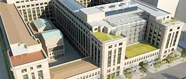 Top view of a large light-stone building with some green roofs