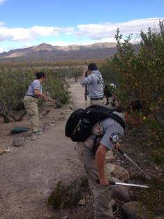 Three Americorps members working on a trail in Ne