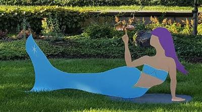 Painted aluminum sculpture of mermaid balancing a