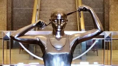 Sculpture of woman blindfolding herself as a symbol of justice at the Warren B. Rudman Courthouse in Concord, NH