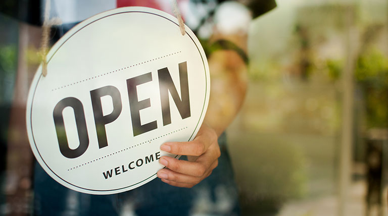 Store owner turning open sign