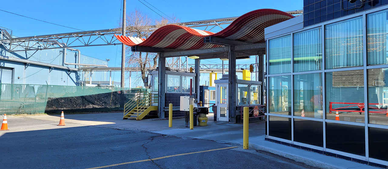 Red and white wavy cover over two drive-through lanes and booths