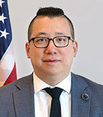 Headshot of Jeffrey Lau. Jeffrey has short black hair and is wearing a blue suit and tie with glasses.