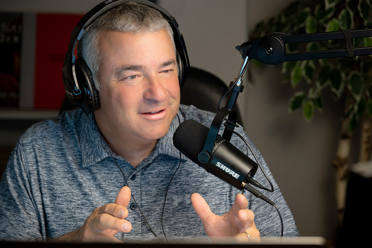 Rob Trubia, a white man wearing black headphones and speaking into a mic