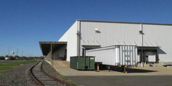 a warehouse building with a trailer in front of it