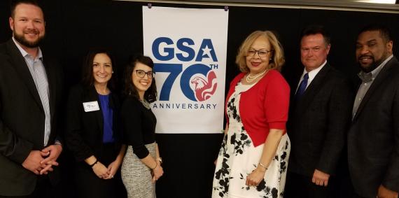 Medium shot of the organizers of the R5 PBS Reverse Industry Day with GSA 70th Anniversary logo behind