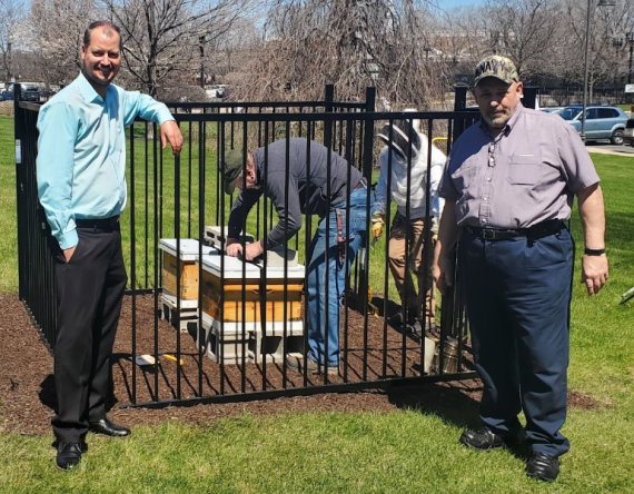 Medium shot of property manager Josh Westhouse and Rich Falzone outside the new bee hive enclosure, U.S. Courthouse, Hammond, IN