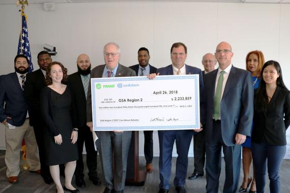 Employees from GSA, ConEdison and Trane pose for a photo with a ceremonial check