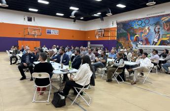 Community members seated while listening to designated speakers