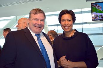 A smiling man and woman in business attire at an office event