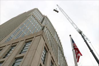 Largest mobile crane hoists a piece of a chiller to the roof of a stone high-rise