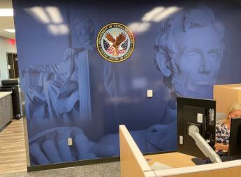 Office wall with blue photographic image of Abraham Lincoln statue and seal
