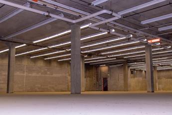 Empty warehouse with columns and fluorescent lighting