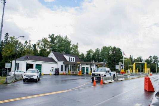 a view of the building from across the street with two cars in the parking lot