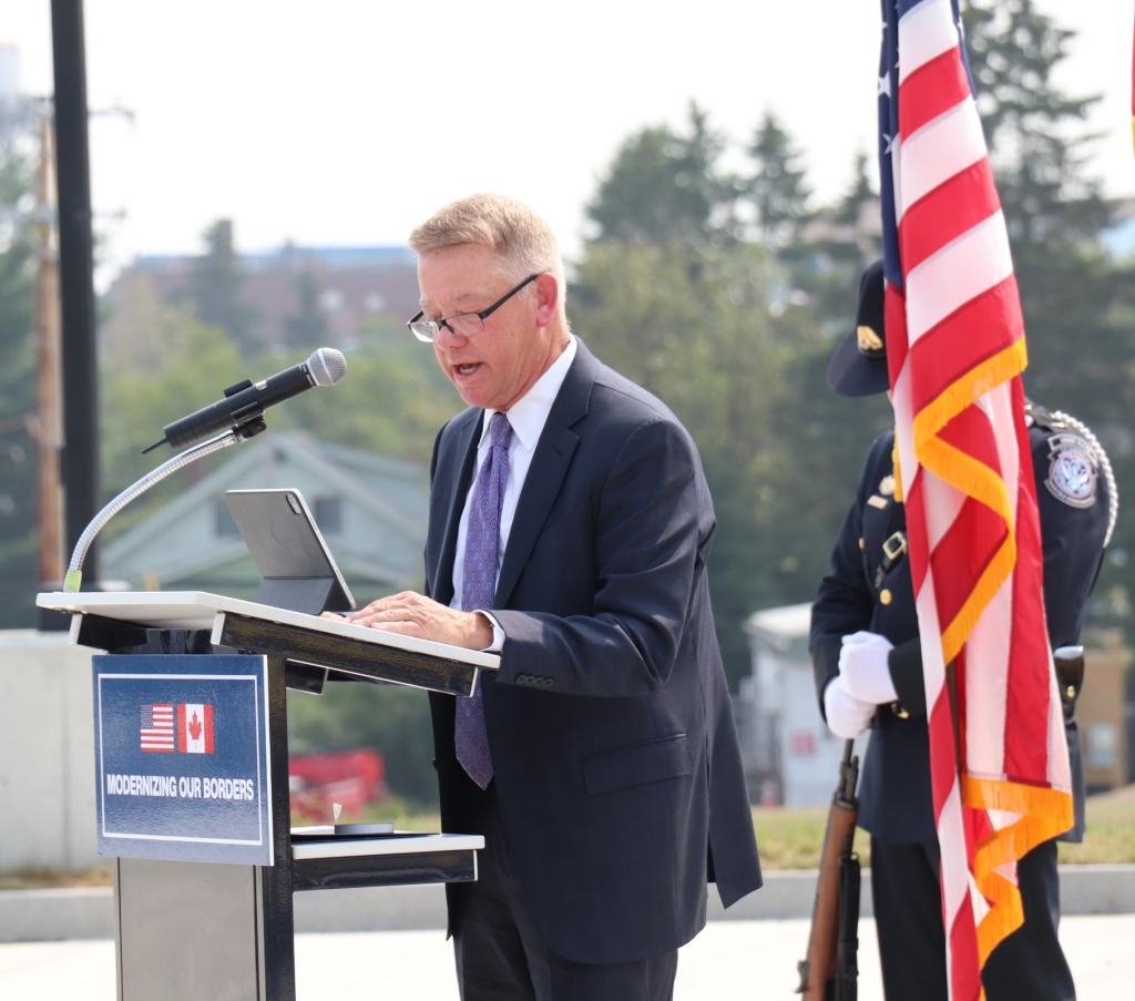 a man in a suit stands at the podium