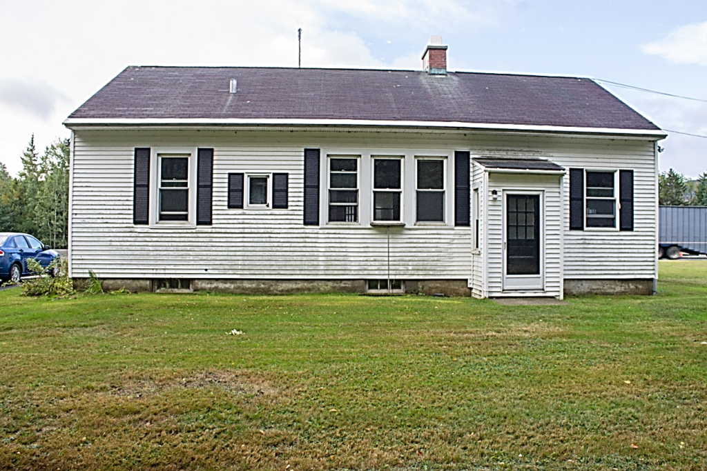 one story white residence with windows and a door