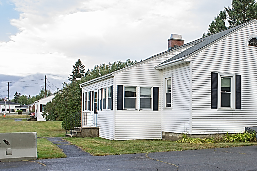 front angle of white one story home from driveway