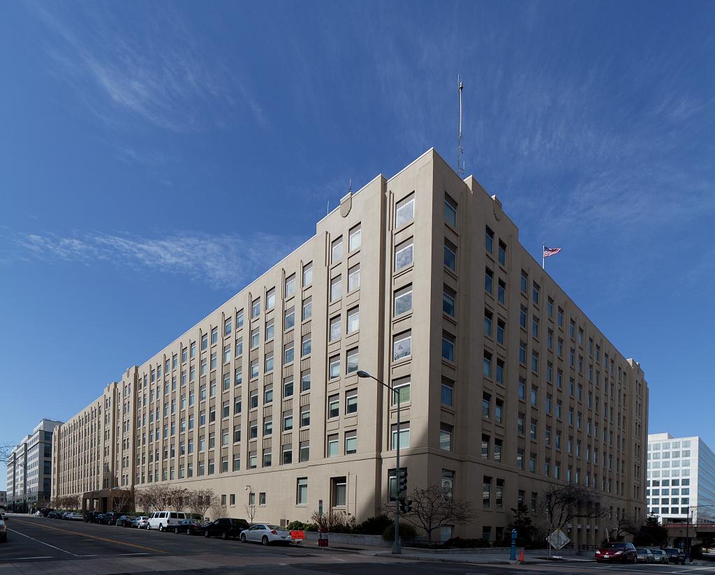 seven-story office building viewed at an angle on a clear blue day