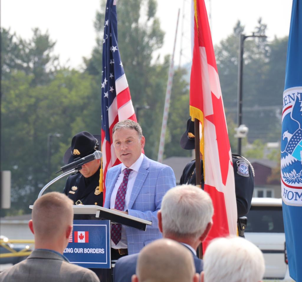 A man in a blue suit stands at the podium