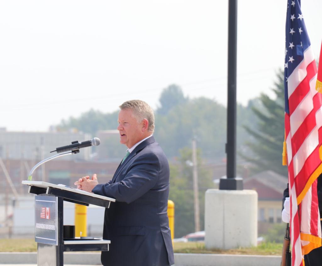 a man in a suit stands at the podium