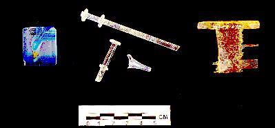 Irish Tenement and Saloon Artifact - Faux gemstone, glass hygienic syringe, and bone lice comb.