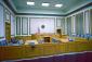 Courtroom interior with inset wall panels, blue seating, and medium blonde woodwork